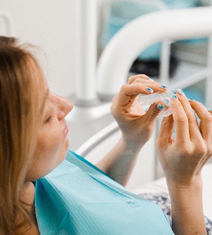 Patient holding clear aligner in treatment chair