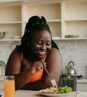 Woman smiling while eating lunch at home