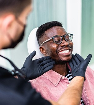 Dentist looking at patient's smile in treatment chair