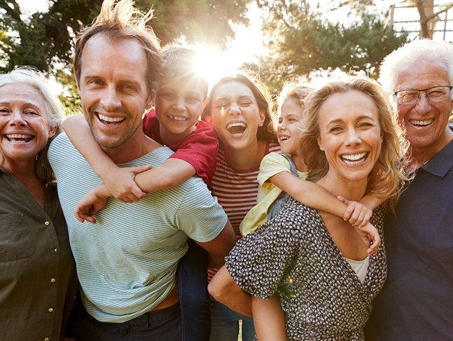 Three generations of a family smiling in the sun