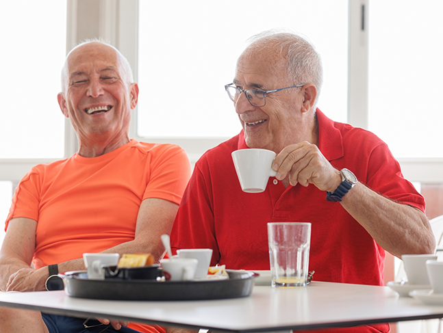 Two senior men enjoying a snack together
