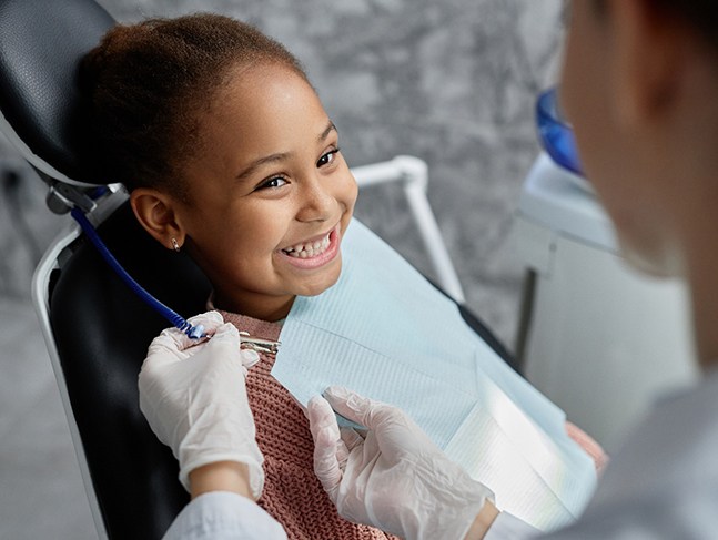Girl in dental chair smiling
