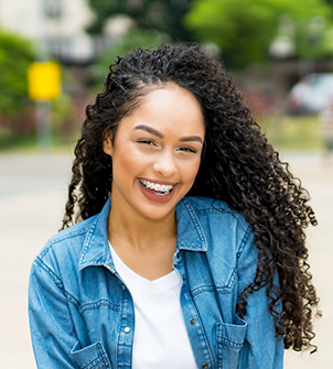 Young woman in a denim jacket smiling