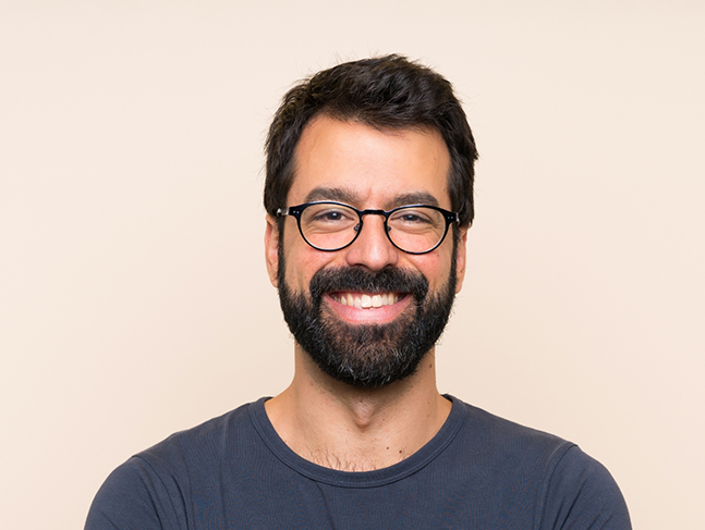 Smiling man with glasses and dark hair and beard