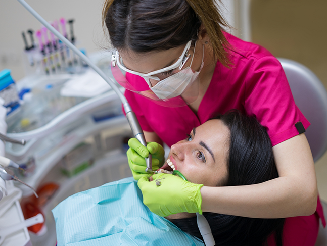 Dental hygienist cleaning a patient's teeth