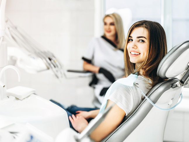 Woman in the dental chair smiling over her shoulder