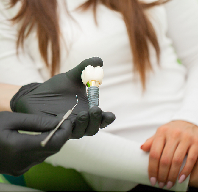 Dentist showing a patient a dental implant in San Antonio