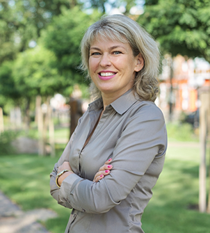 Woman with short gray hair smiling in a park