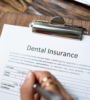 Person filling out dental insurance paperwork