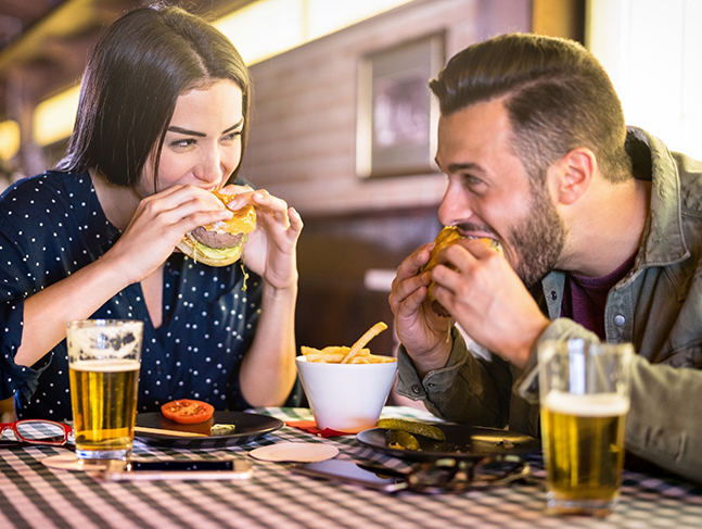 Man and woman enjoying burgers at a restaurant