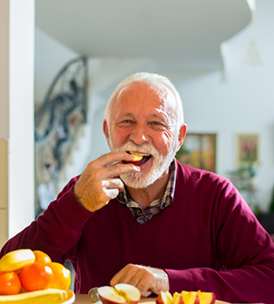 Senior man enjoying apple slices at home