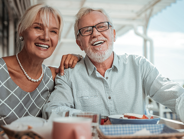 Senior couple eating at an outdoor table at a restaurant