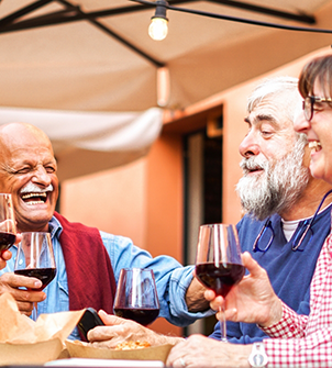 Senior enjoying red wine at a table