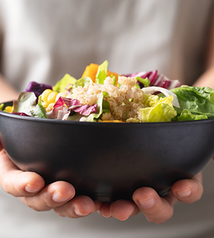 Person holding a bowl of salad