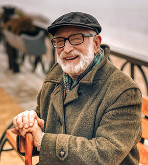 Smiling senior man sitting and holding his cane