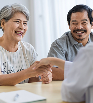 Senior woman shaking hands with the person across the table from her