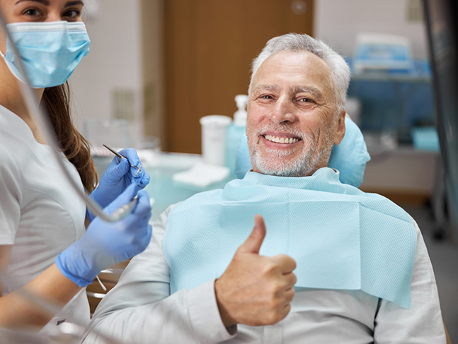 Senior man giving a thumbs up in the dental chair