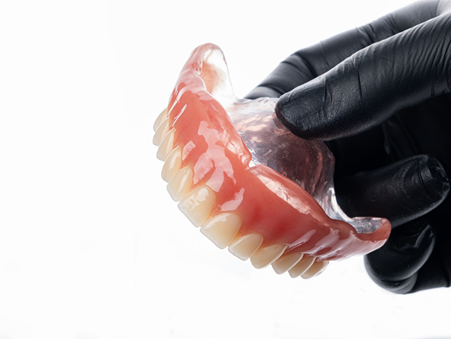 Dentist holding a full denture
