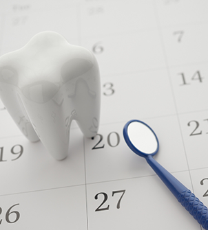 Model of a tooth and a dental mirror on a calendar