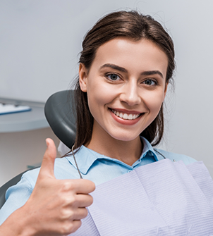 Woman giving a thumbs up in the dental chair