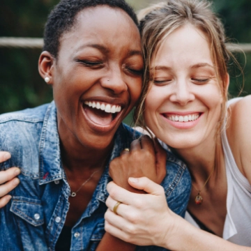 Two women laughing and hugging