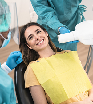 Woman in the dental chair smiling at her dentist