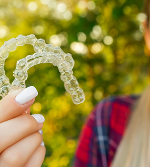 Hand holding two Invisalign aligners