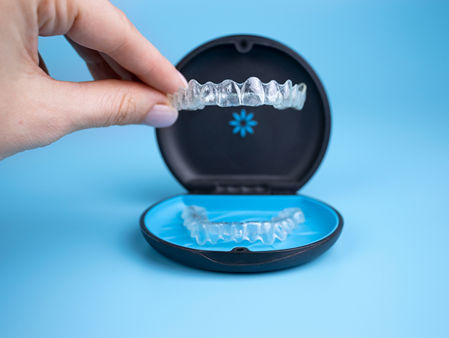 Hand placing Invisalign in its plastic case