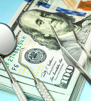 Dental instruments on top of a stack of cash