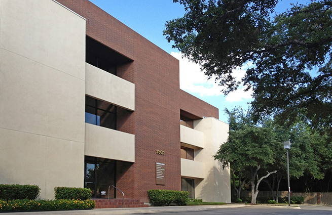 Dark red brick exterior of a dental office building in San Antonio