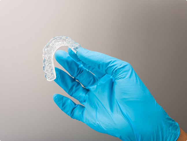 Dentist holding a clear nightguard