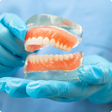 Dentist holding a model of dentures