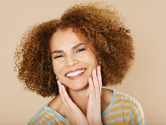 Smiling woman touching her face