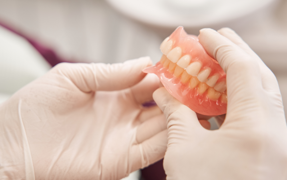 Dentist holding dentures
